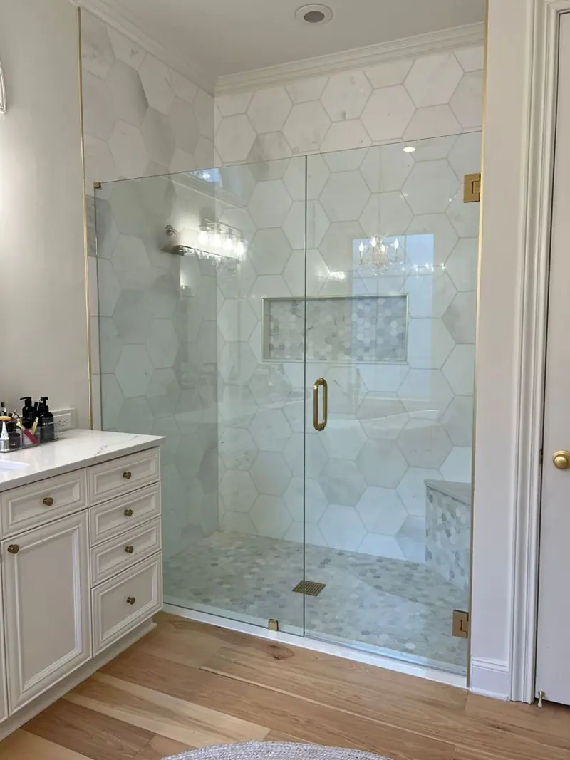 Marble walk-in shower with a frameless glass door